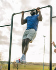 Man wearing the blue MOVE Sport Apparel men’s LuxDry Training T-Shirt during an outdoor pull-up.
