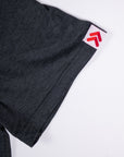 Close-up of a charcoal grey MOVE sport apparel Essential Polo Shirt sleeve with a red logo tag on the cuff