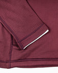 Close-up of MOVE sport apparel women's burgundy waffle-knit hoodie showing textured fabric and sleeve detail.