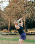 MOVE sport apparel black cropped tank top worn by a woman swinging a golf club on a course