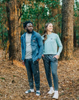 MOVE sport apparel woman wearing a light blue long sleeve crewneck sweatshirt with ribbed cuffs in a forest setting