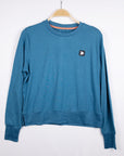 MOVE sport apparel blue heathered long sleeve crewneck sweatshirt with ribbed cuffs and side-slit hem on a hanger.