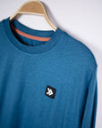 MOVE sport apparel blue heathered long sleeve crewneck sweatshirt with a signature Black Label patch on a hanger
