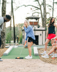 MOVE Sport Apparel women’s Black Label Lightweight Sun Hoodie: Friends playing miniature golf with a woman wearing the Deep Periwinkle sun hoodie.