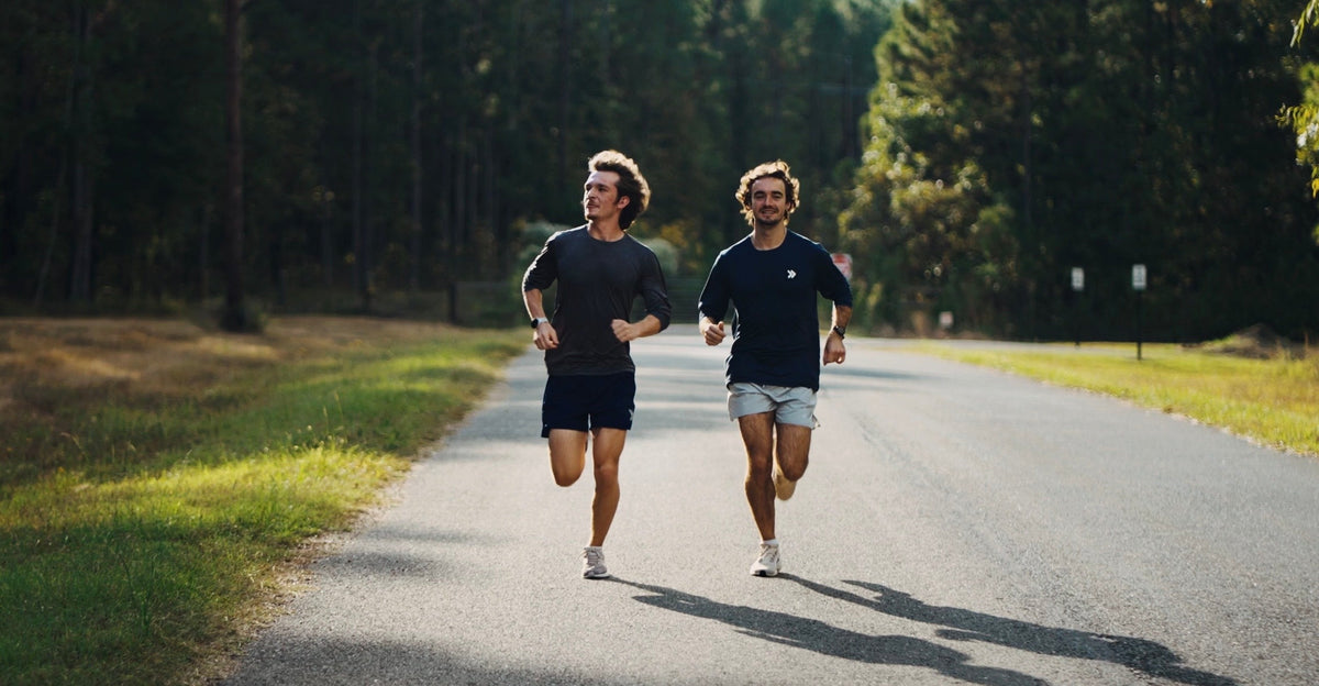 Two runners training on a sunny Louisiana road for MOVE Journal's heat, hydration and fueling guide