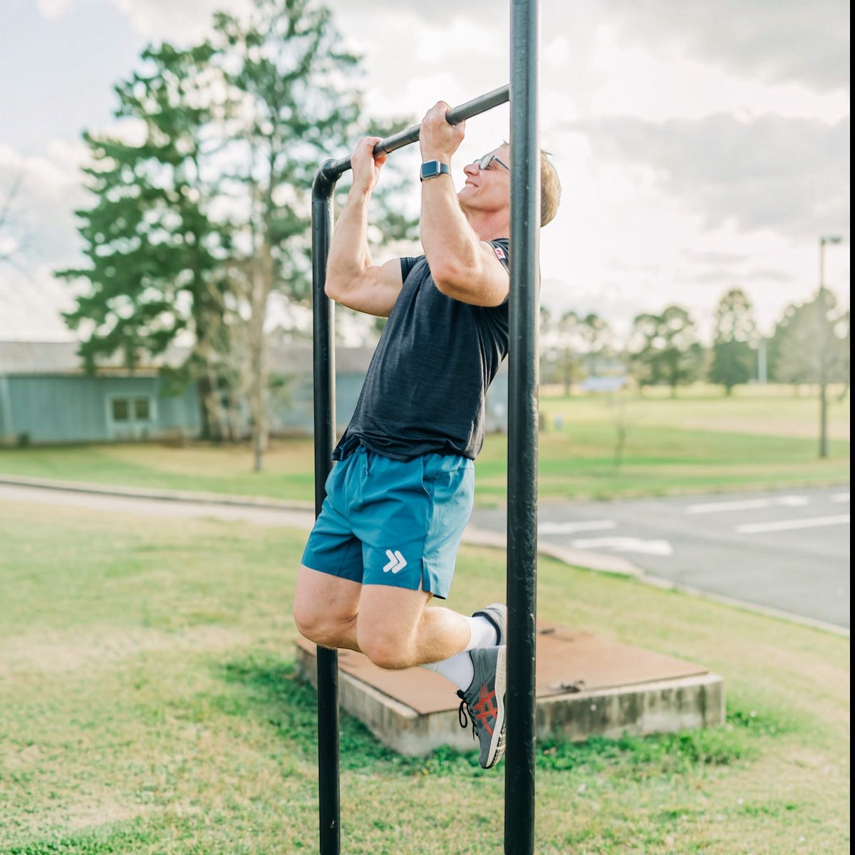 MOVE Sport Apparel Agility 6 inch training shorts in blue worn by a man doing pull-ups on an outdoor bar