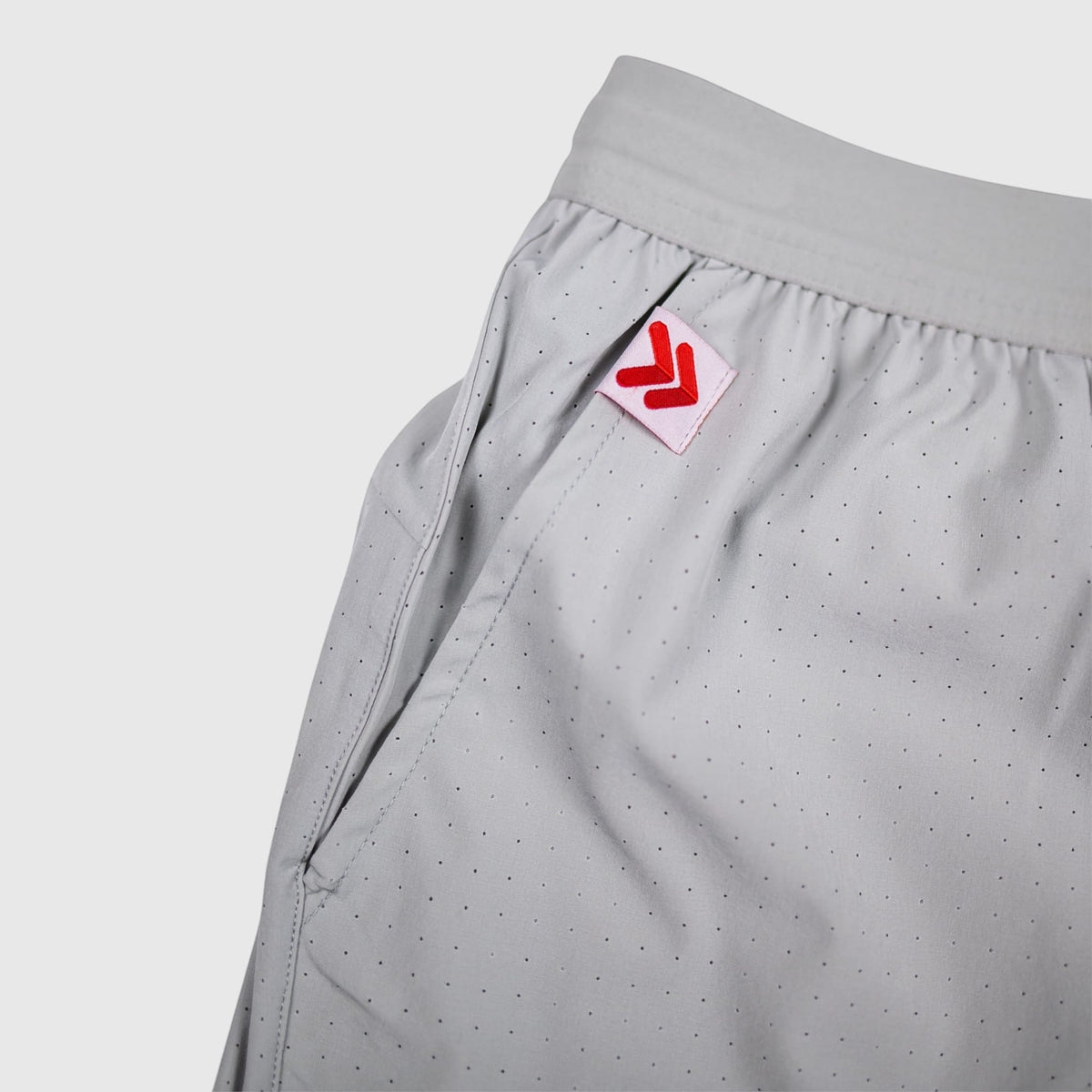 MOVE Sport Apparel Agility training shorts in light grey with perforated fabric and red logo tab on the pocket