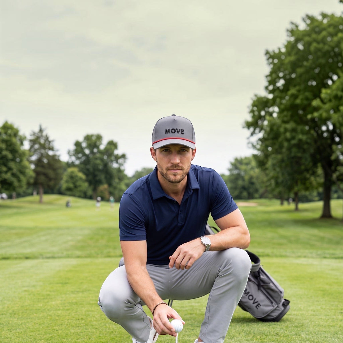 Man wearing the Castlerock Performance Trucker hat while kneeling beside a golf ball on a course.