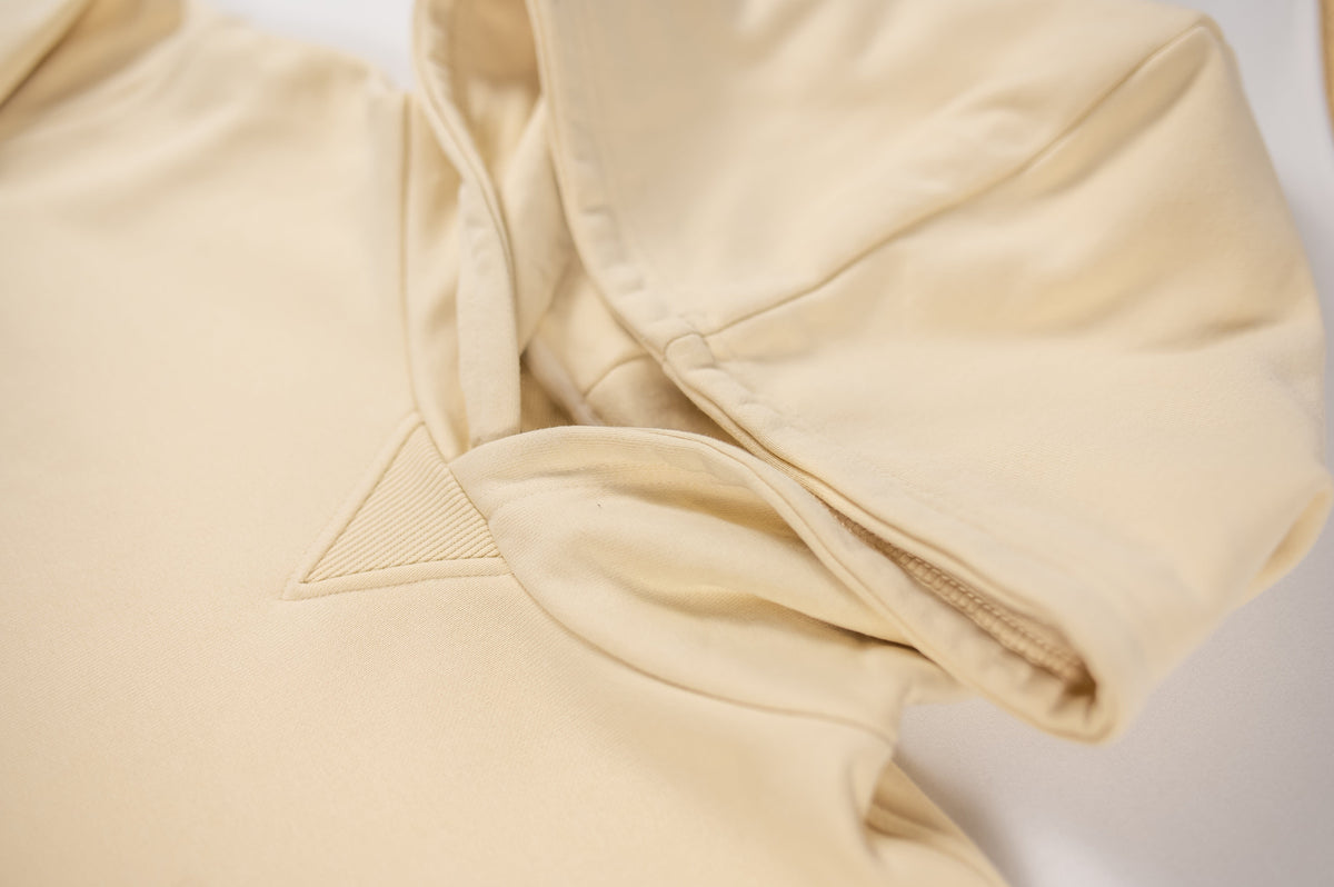 Folded detail of the MOVE Sport Apparel French Terry Hoodie in Natural.