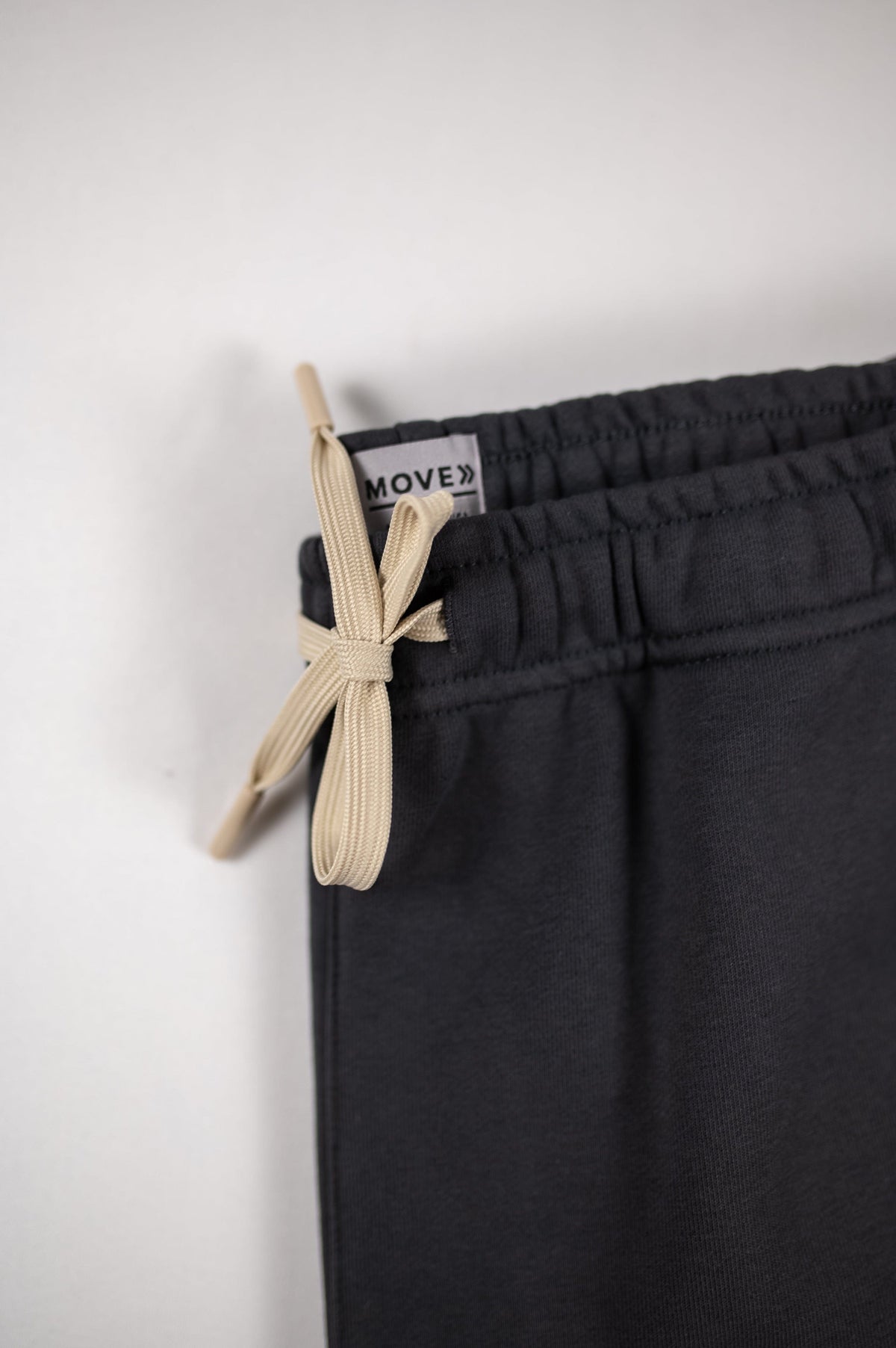 Close view of the contrast drawstring and original waistband label on MOVE Sport Apparel French Terry Joggers in Volcanic Ash.