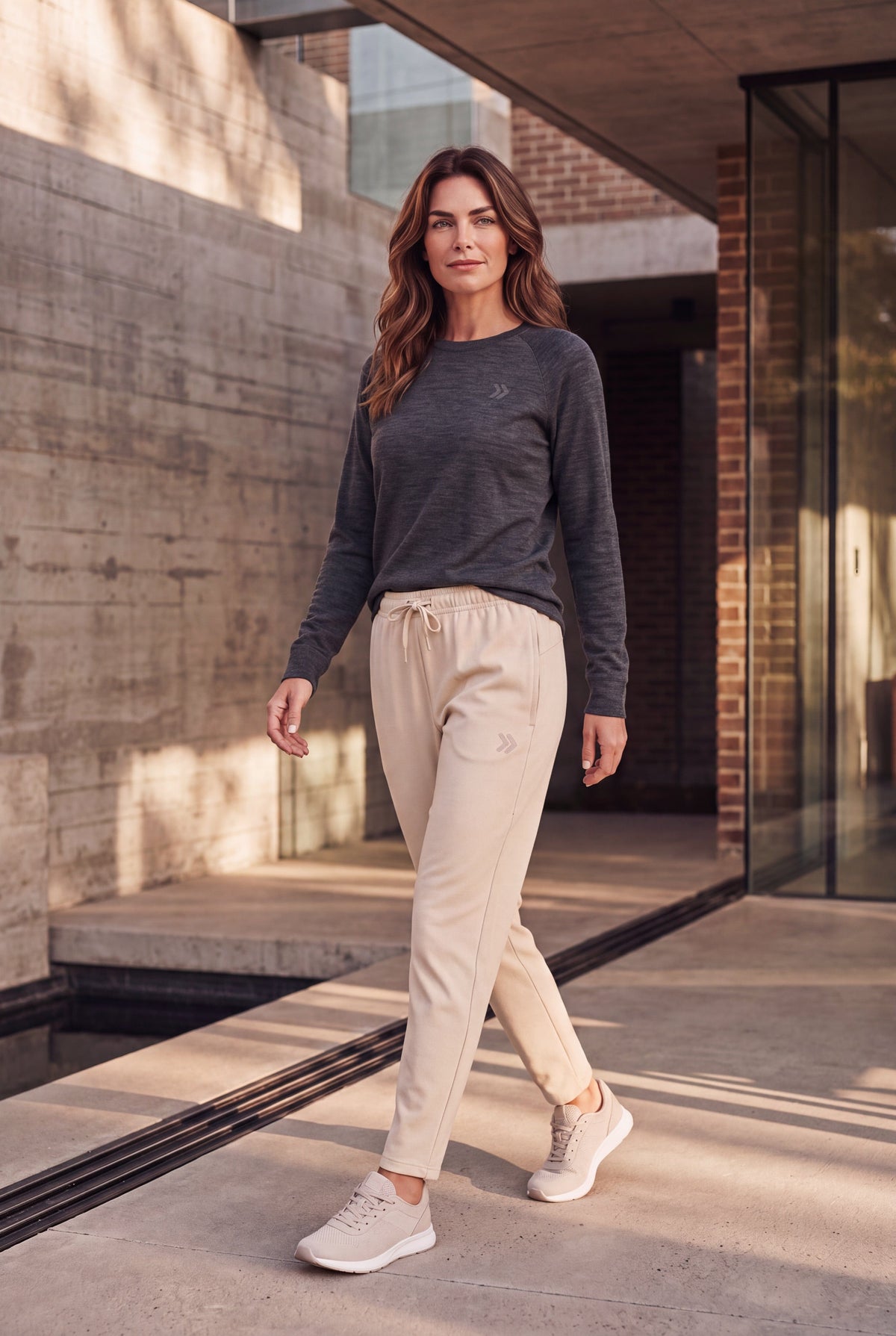 Woman walking outside in MOVE Sport Apparel French Terry Joggers in Natural with a dark long sleeve top.