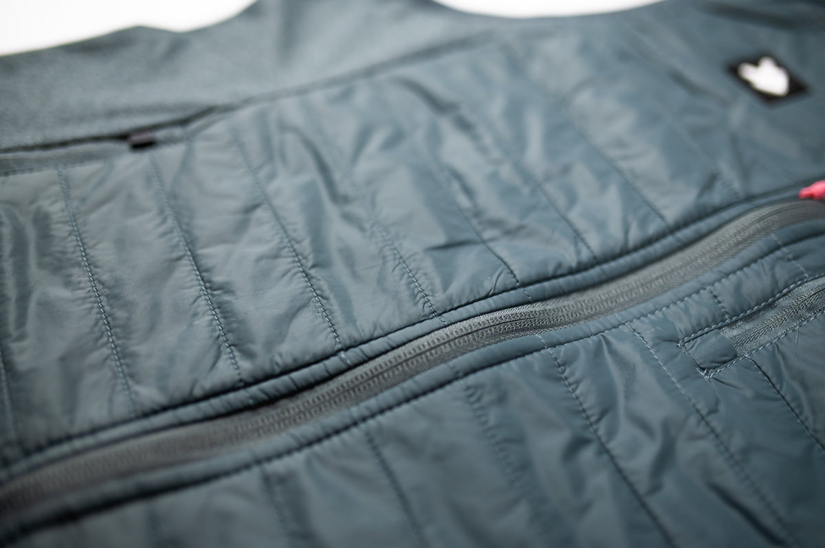 Close-up of the grey MOVE Sport Apparel men’s down vest side pocket and quilted fabric.