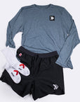Blue Mirage Black Label long sleeve top styled with black athletic shorts and white socks in a flat-lay outfit.