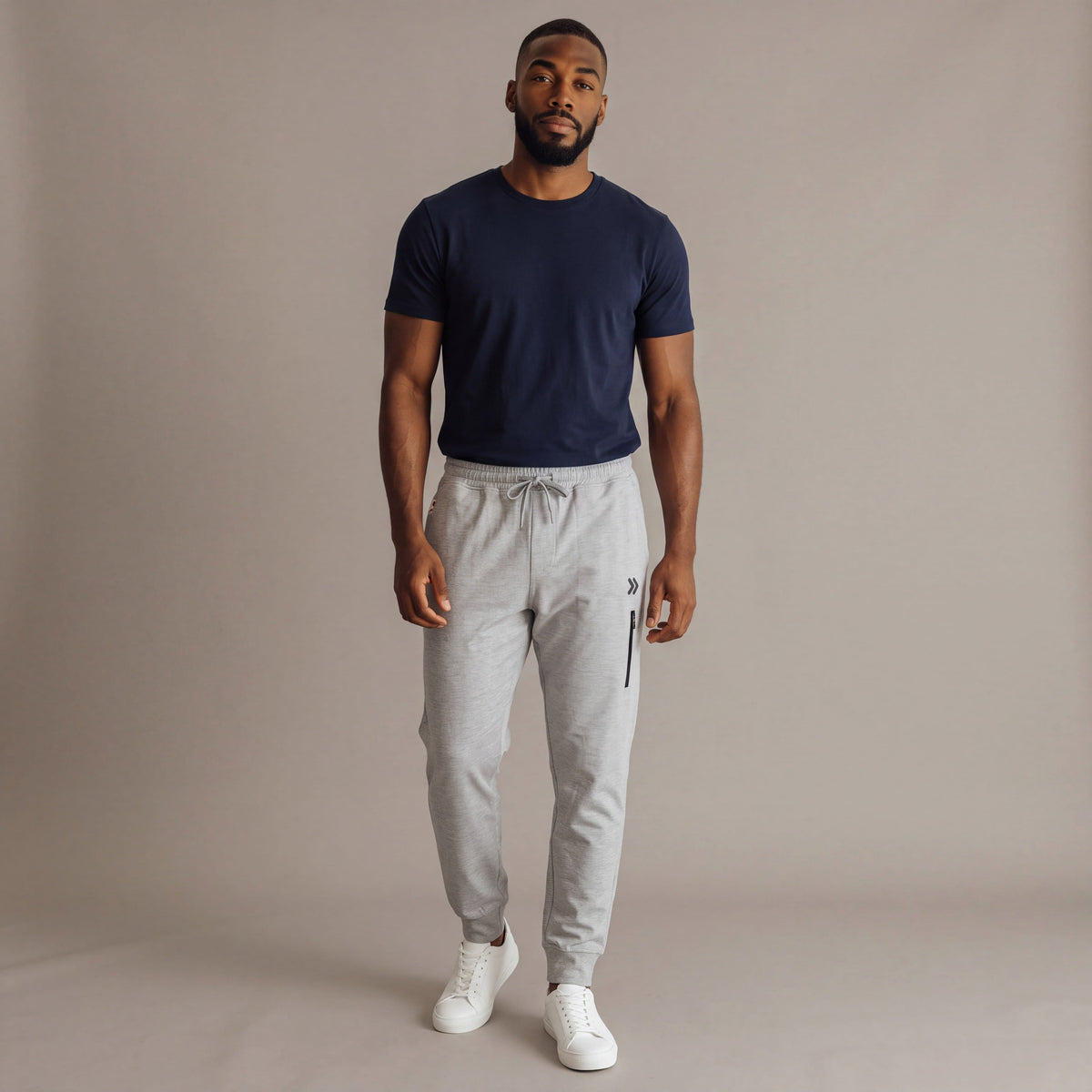 Man modeling MOVE Sport Apparel Men’s Essential Jogger Black Label in Silver Cloud in a neutral studio.