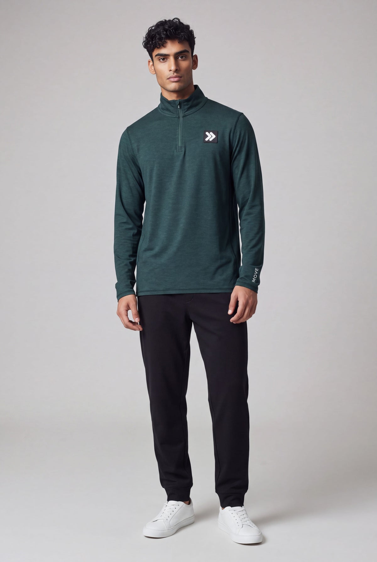 Full-body neutral studio view of a man wearing MOVE Sport Apparel men’s Essential Quarter Zip in Pine Grove.