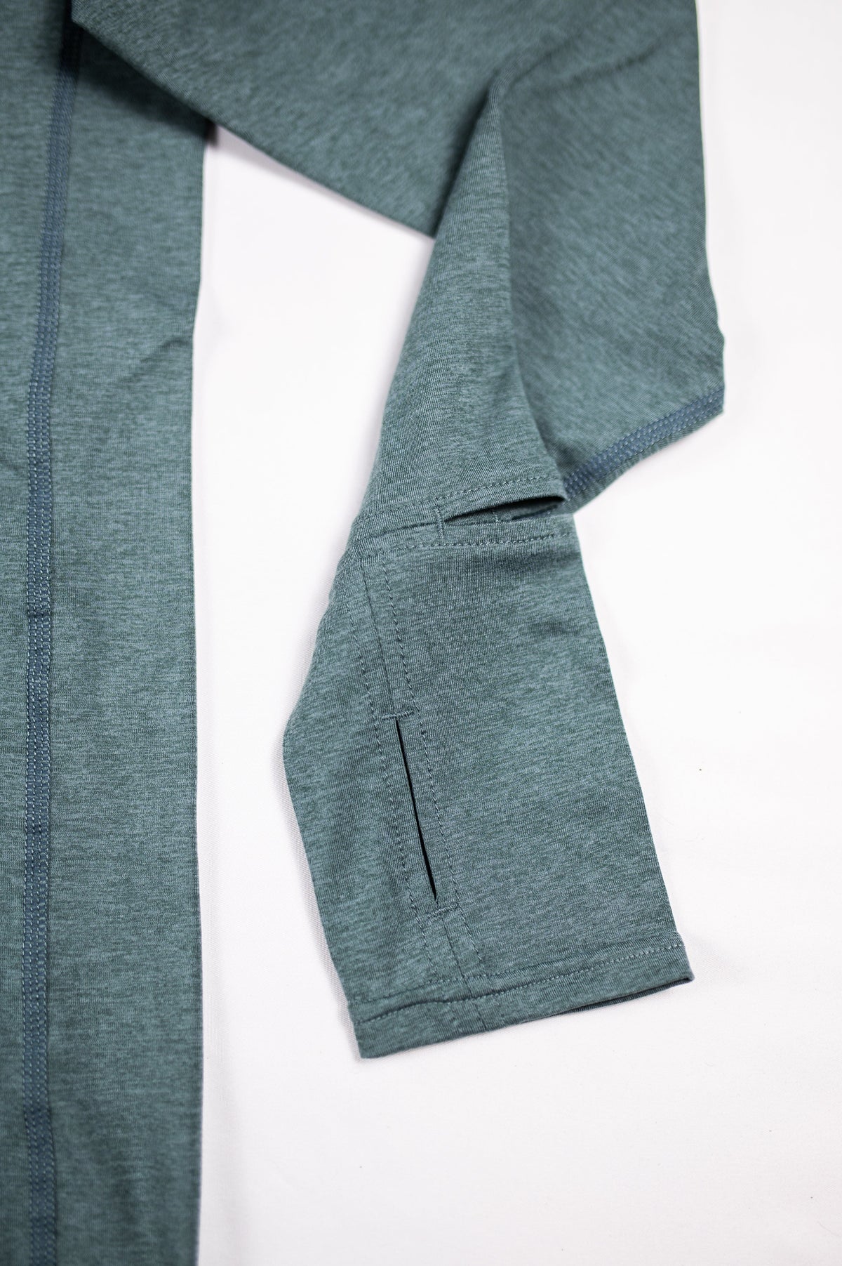 Close view of the Balsam Green Essential Quarter Zip Pro sleeve cuff and thumb opening.