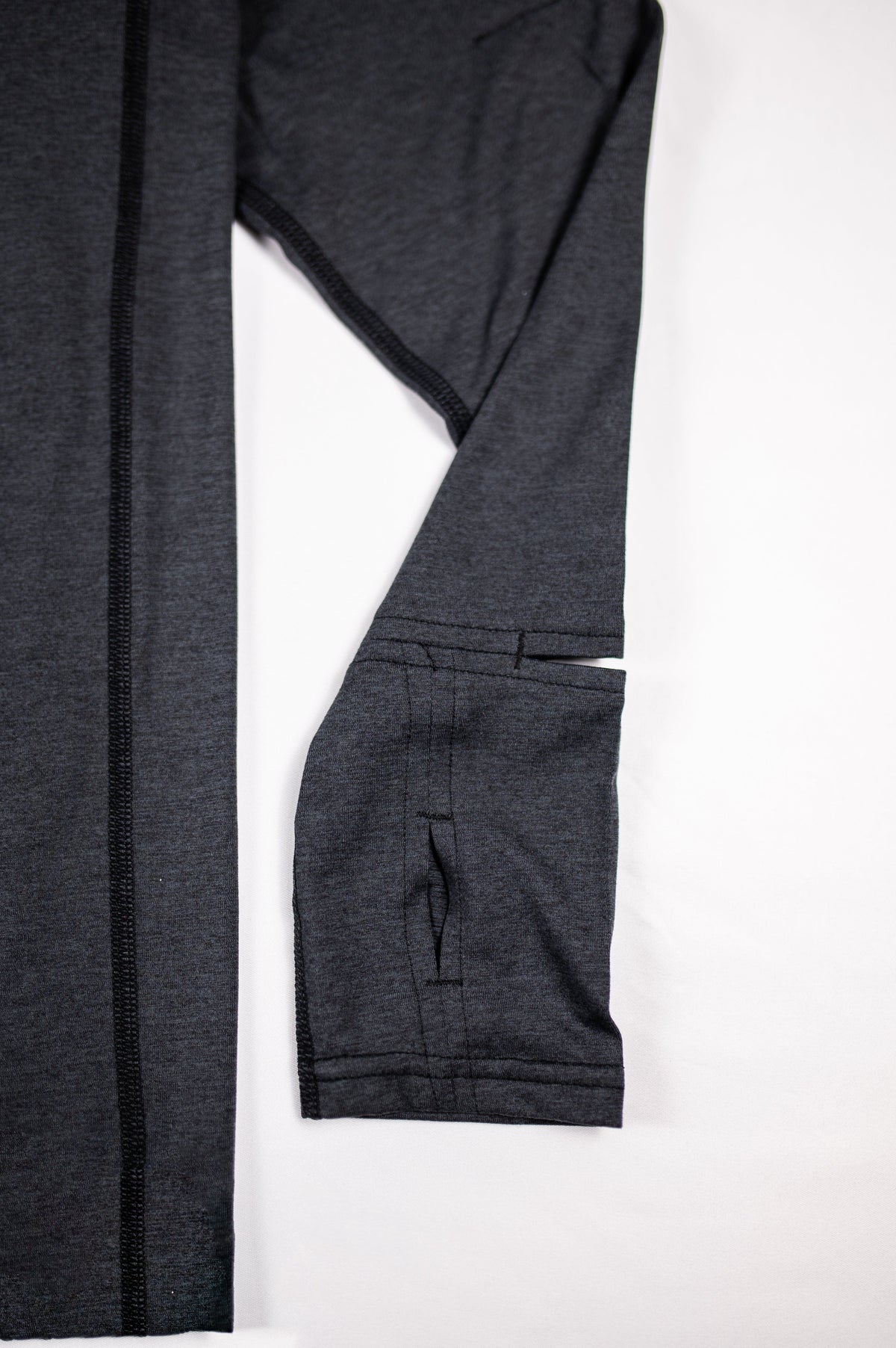 Close view of the Heather Black Essential Quarter Zip Pro sleeve cuff and thumb opening.