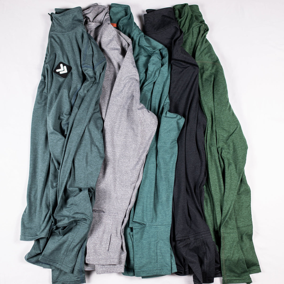 Five MOVE Sport Apparel men’s Essential Quarter Zip Pro colors arranged together, showing original collars, chest patches and sleeve pockets.