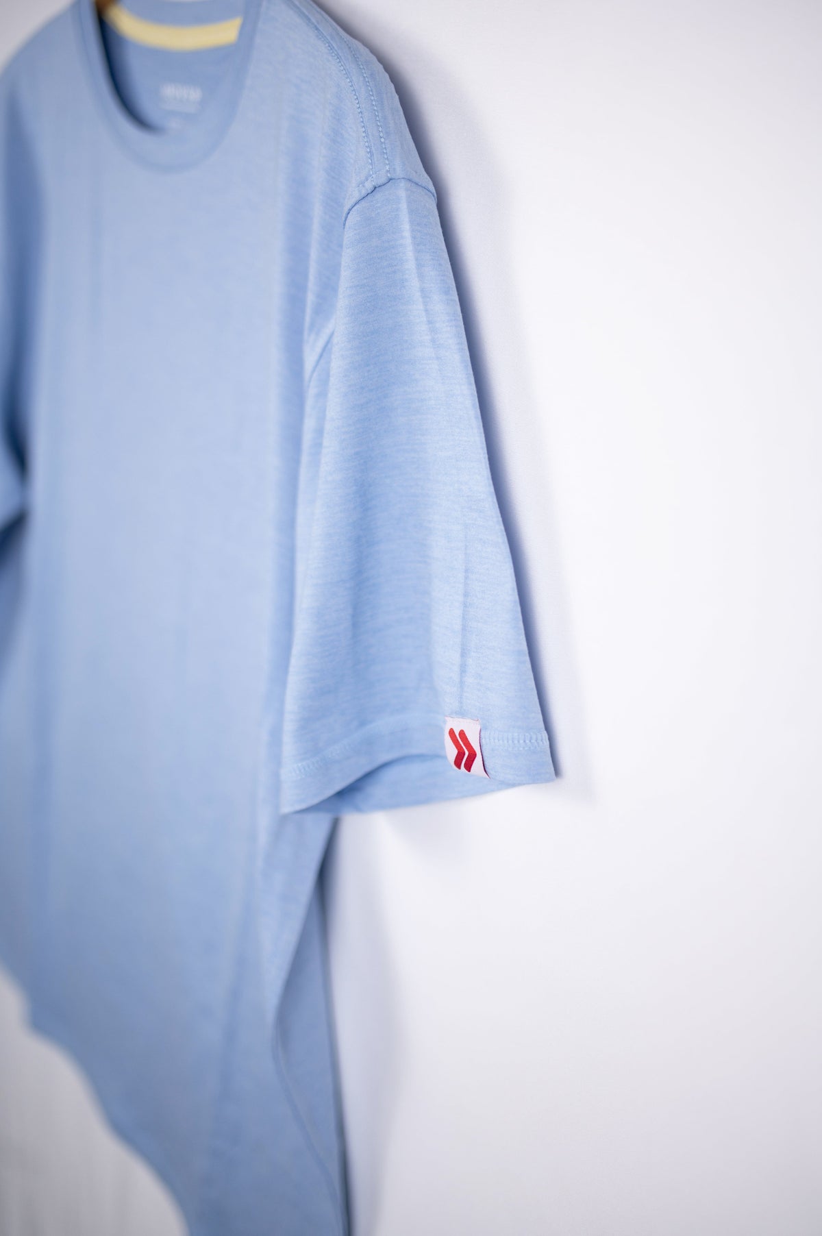 MOVE Sport Apparel men’s Essential Short Sleeve: Heather Chambray Blue shirt showing its original sleeve tab.