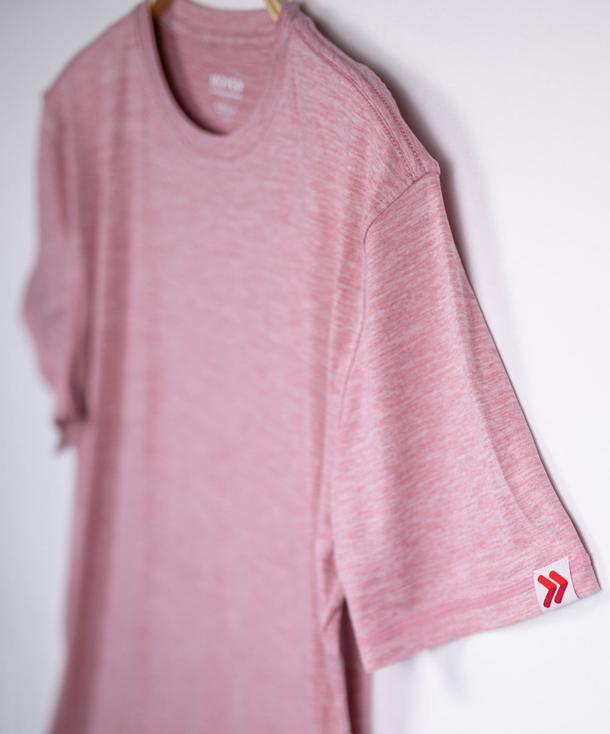 MOVE Sport Apparel men’s Essential Short Sleeve: Heather Crimson shirt shown at an angle with sleeve detail.