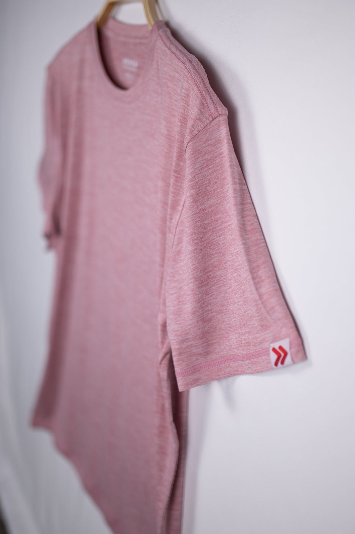 MOVE Sport Apparel men’s Essential Short Sleeve: Heather Crimson shirt with a close view of its original sleeve tab.