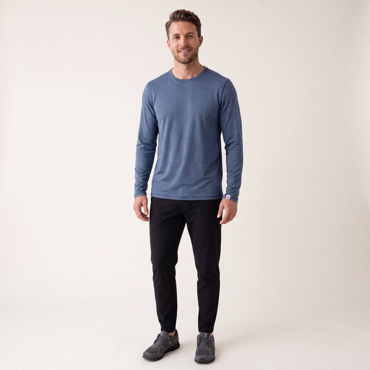 Full-body studio view of a man wearing MOVE Sport Apparel men’s LuxDry long sleeve in Naval academy.