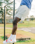 Blue LuxDry tee and light shorts worn during an outdoor pull-up, cropped outfit detail.