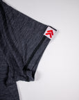 Close-up of the original white tab with red double chevrons at the Asphalt merino tee sleeve hem.