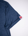 Midnight Sail blue merino tee sleeve hem showing its original white-and-red double-chevron tab.