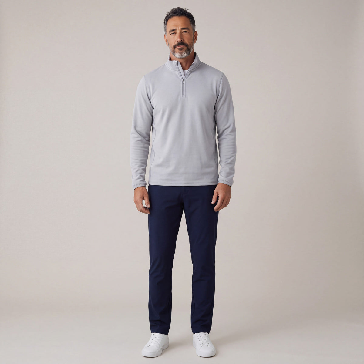 Adult man modeling the men’s Silver Cloud Performance Quarter Zip Pullover with navy trousers in a neutral studio.