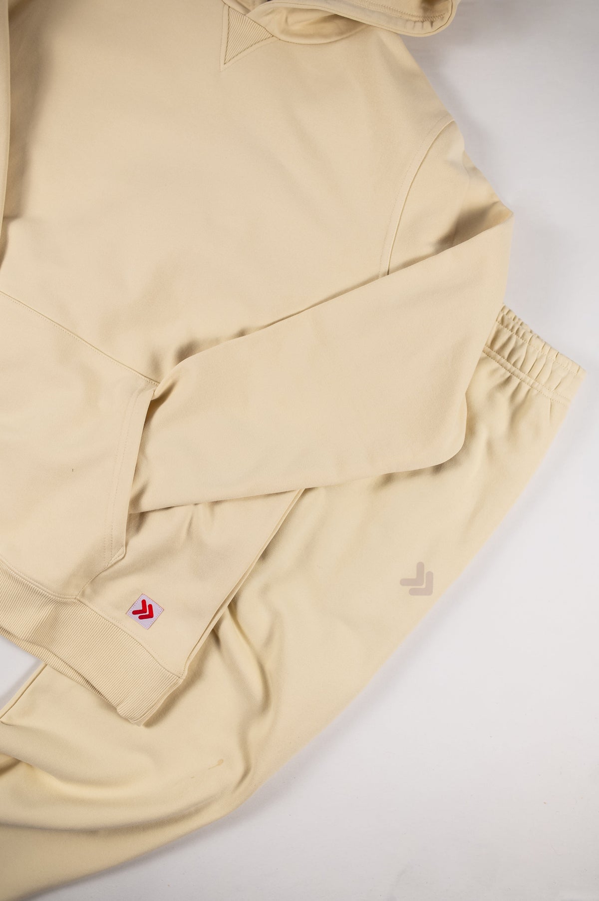 Close view of the original embellishments on a MOVE Sport Apparel French Terry Hoodie and jogger outfit in Natural.