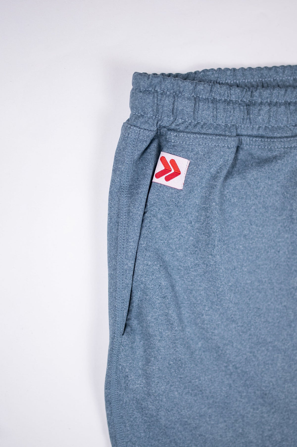 Blue Mirage MOVE Sport Apparel men’s Essential Jogger rear pocket with original white and red embellishment.
