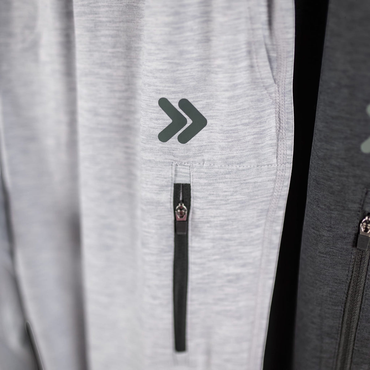 Close view of the original thigh embellishment and zip pocket on MOVE Sport Apparel Men’s Essential Jogger Black Label in Silver Cloud.