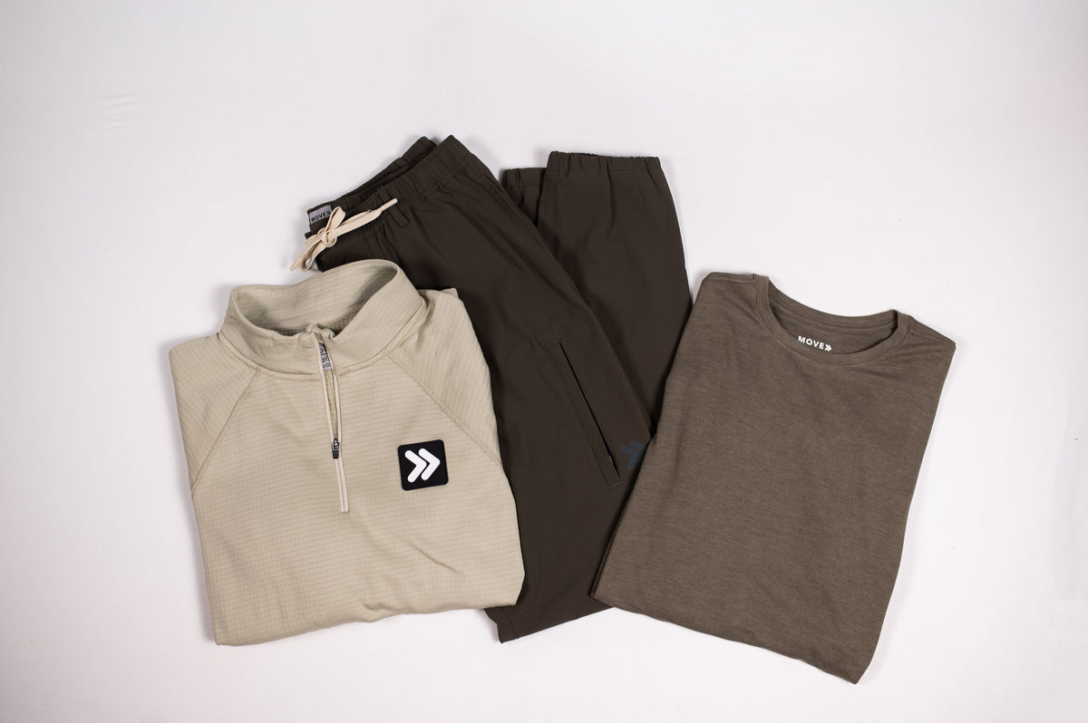 Neutral MOVE Sport Apparel garments arranged together with dark athletic shorts in a coordinated flat lay.