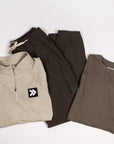 Neutral MOVE Sport Apparel garments arranged together with dark athletic shorts in a coordinated flat lay.