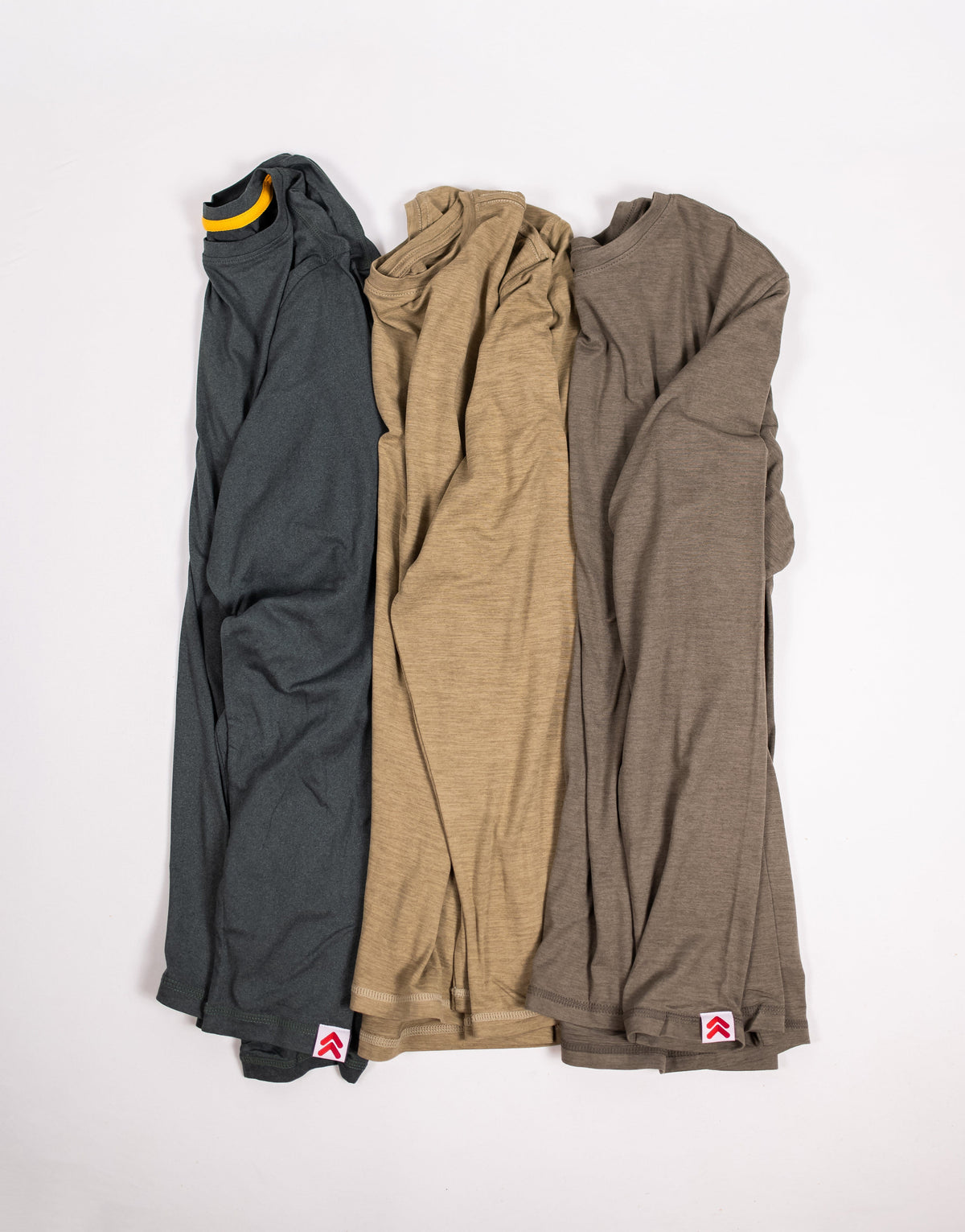 MOVE Sport Apparel Men’s Essential Long Sleeve shirts in three colors arranged together in a flat lay.