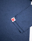 Close view of the red-and-white cuff label and fabric on the Pageant Blue MOVE Sport Apparel Men’s Essential Long Sleeve.