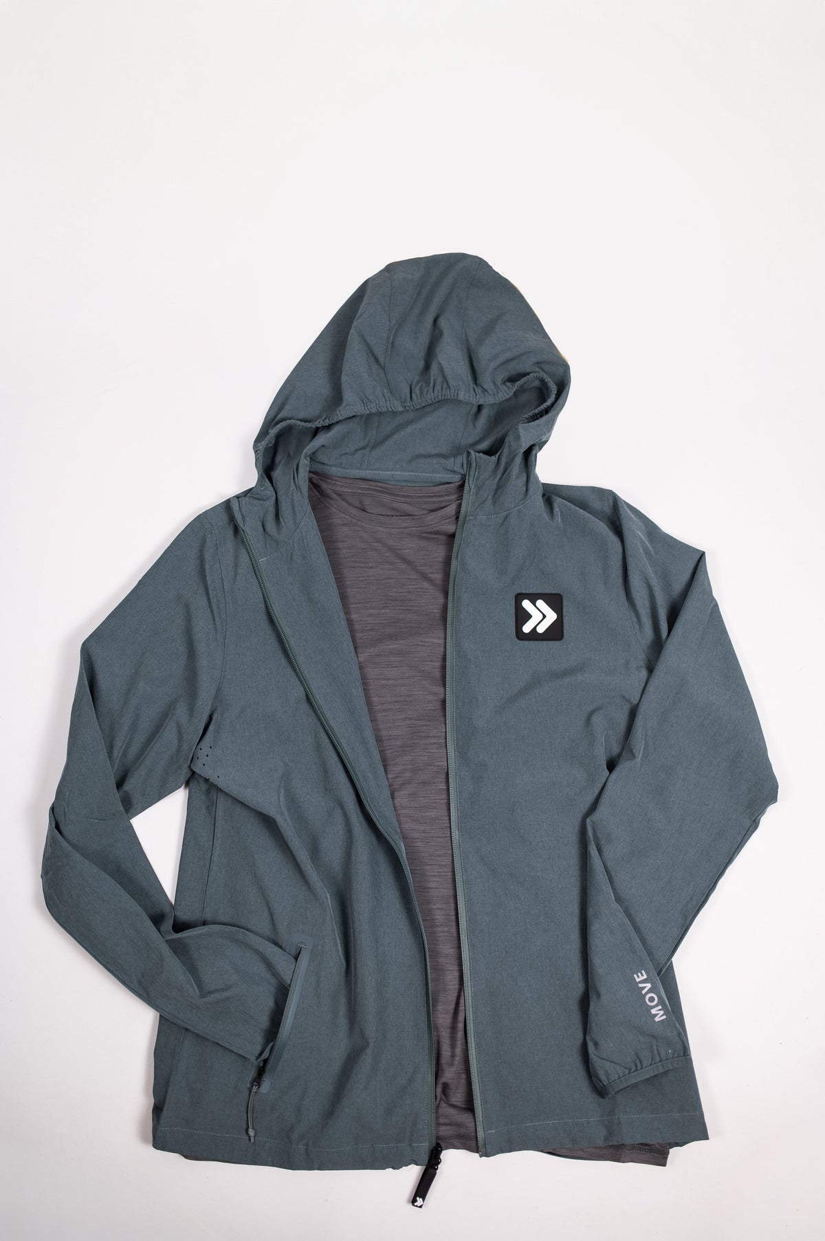 MOVE Sport Apparel Men’s Merino Long Sleeve in Granite Gray styled under a hooded jacket in a flat lay.