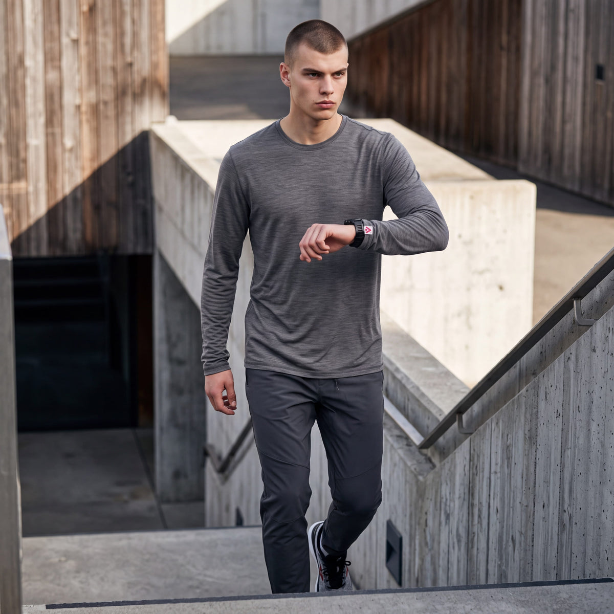 Man wearing MOVE Sport Apparel Men’s Merino Long Sleeve in Granite Gray on concrete stairs.