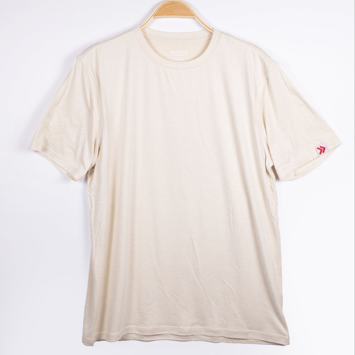MOVE Sport Apparel men’s Essential Short Sleeve: Heather Sand shirt shown from the front on a hanger.