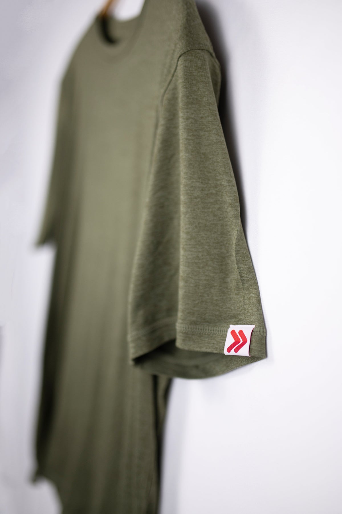 MOVE Sport Apparel men’s Essential Short Sleeve: Heather Hunter Green shirt showing its original sleeve tab.