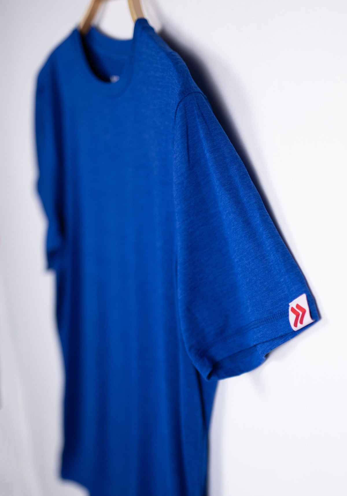 MOVE Sport Apparel men’s Essential Short Sleeve: Surf the Web blue shirt with its original sleeve tab in close view.