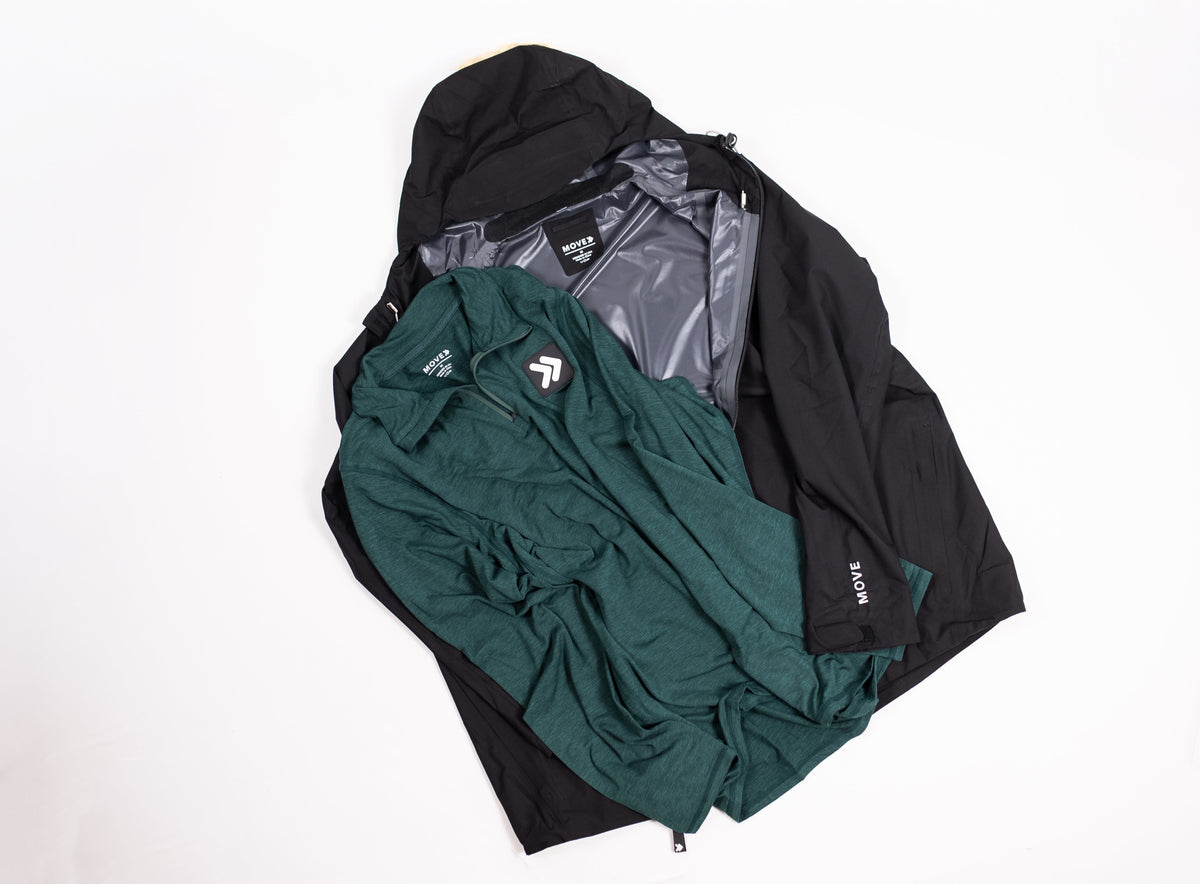 MOVE Sport Apparel Men’s Essential Quarter Zip in Pine Grove styled with a dark jacket in a flat lay.