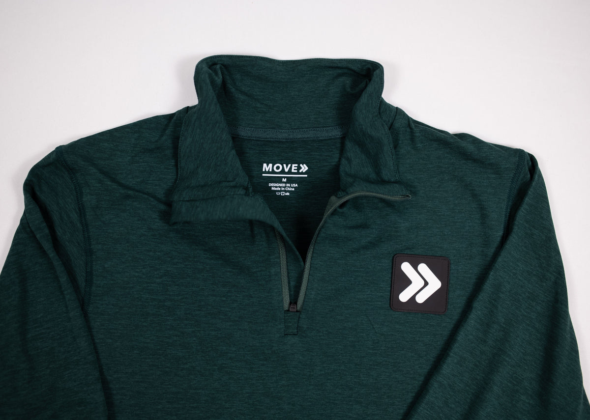 Close view of the collar, zipper and original chest patch on MOVE Sport Apparel Men’s Essential Quarter Zip in Pine Grove.