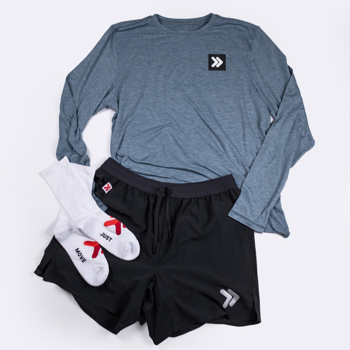 Blue Mirage Black Label long sleeve top styled with black athletic shorts and white socks in a flat-lay outfit.