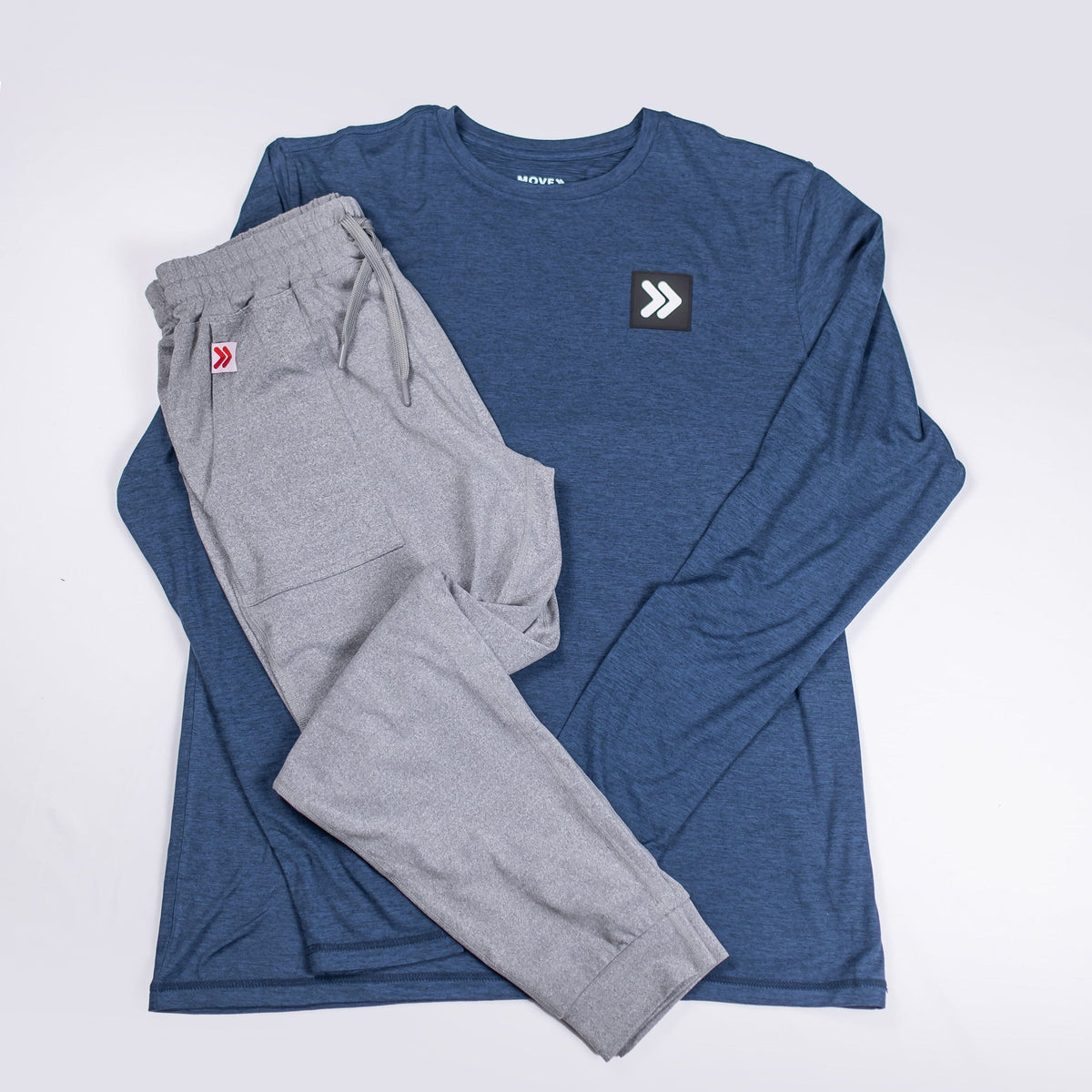 MOVE Sport Apparel Pageant Blue Black Label long sleeve and grey trousers arranged as a flat-lay outfit.