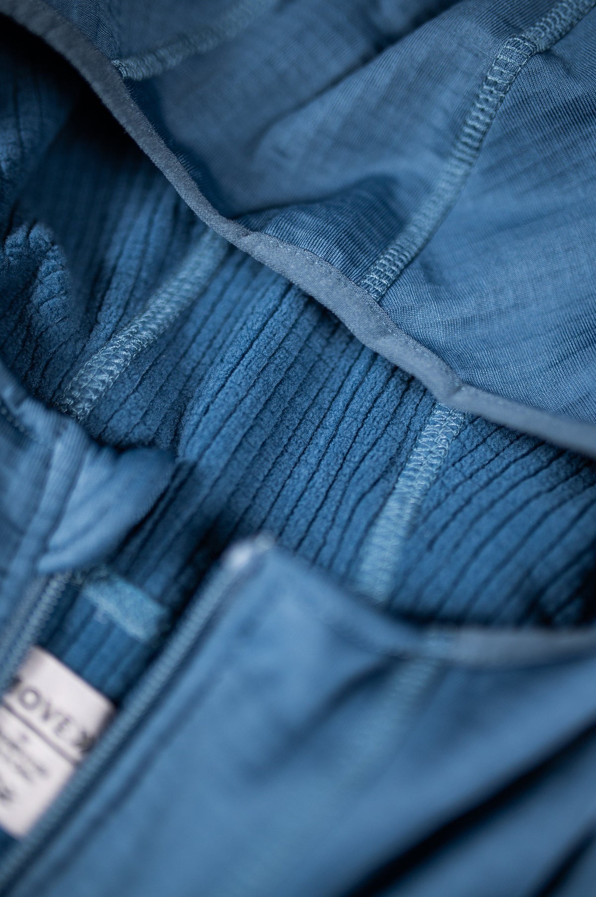 Close view of the Blue Mirage waffle hooded jacket hood, zipper and textured knit.