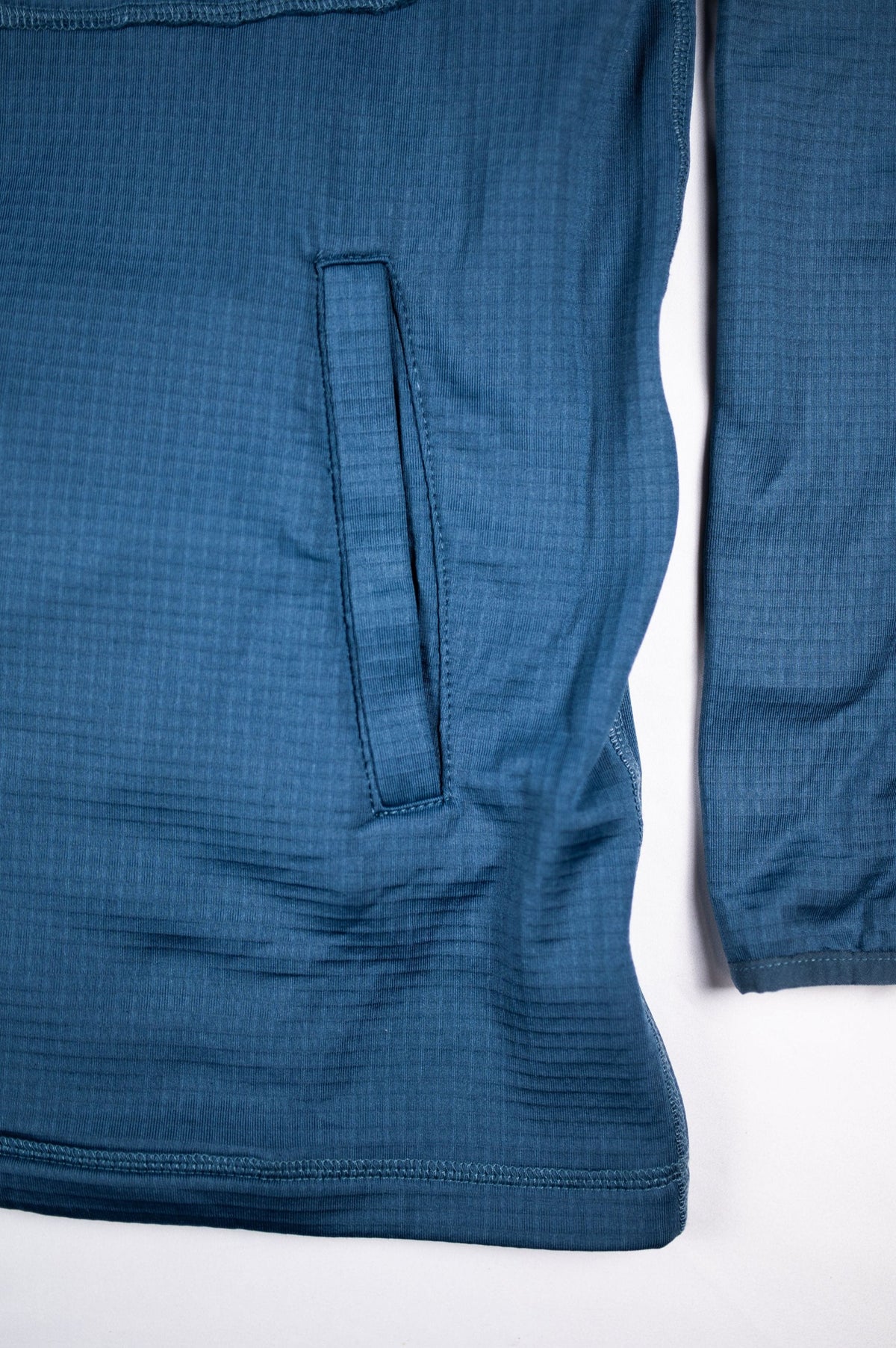 Close view of the Blue Mirage waffle hooded jacket side pocket, sleeve and hem.