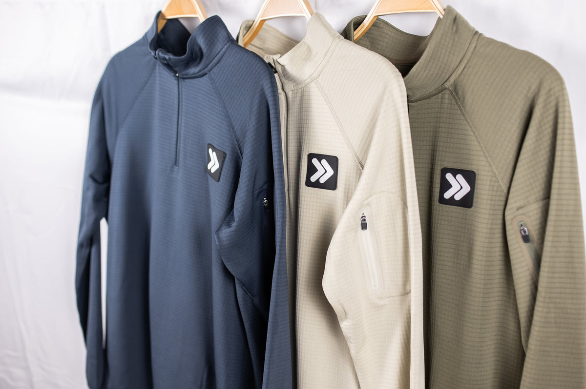 MOVE Sport Apparel men’s waffle quarter zips in dark blue, Pelican and Smokey Olive displayed together on hangers.