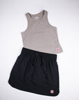 MOVE sport apparel women's taupe cropped tank top paired with a black athletic skort for fitness and workouts.